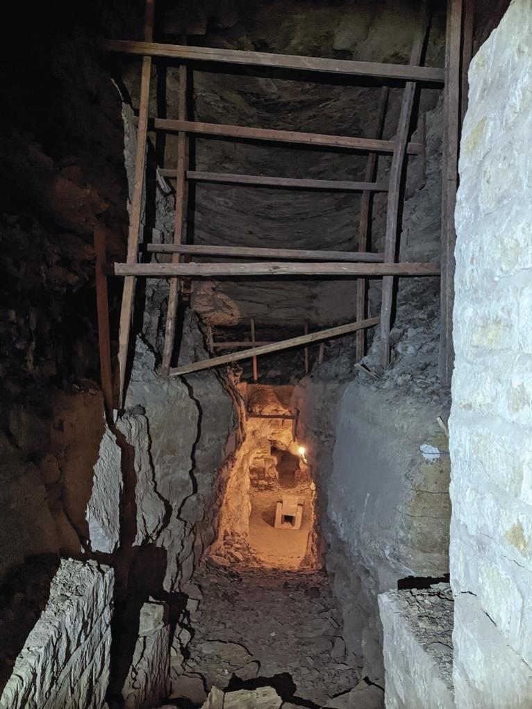 Dernier tronçon de la descenderie, étayé par des pièces de charpente durant l’exploration de Zakaria Goneim. La chambre funéraire et son sarcophage se situent au fond en arrière-plan.