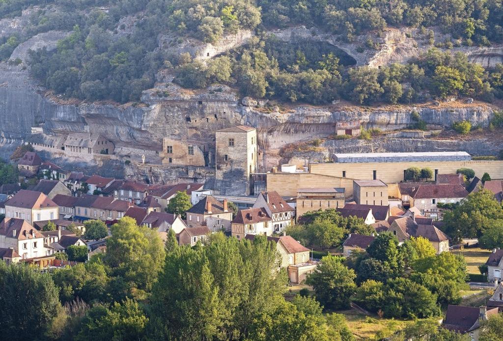 Vue générale du musée national de Préhistoire au pied de la grande falaise des Eyzies. De droite à gauche : le musée actuel, le château, la statue L’Homme primitif (œuvre de Paul Dardé), la terrasse du Grand Abri et les réserves.