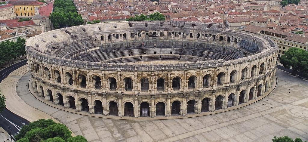 Vue aérienne de l’amphithéâtre ; au premier plan sur le parvis, le tracé de l’enceinte augustéenne.