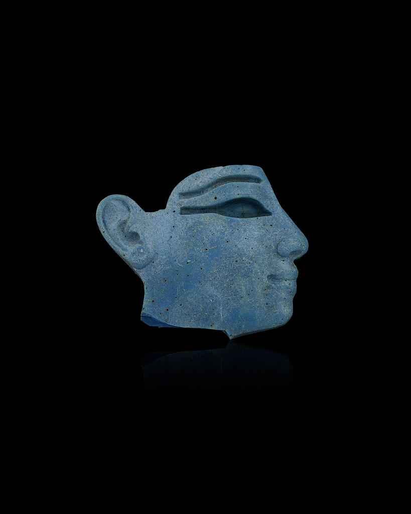 Élément d’incrustation en forme de tête, Égypte, Nouvel Empire, XIXe-XXe dynastie, vers 1292-1070 avant J.-C. Verre, 3,8 x 4,6 cm.