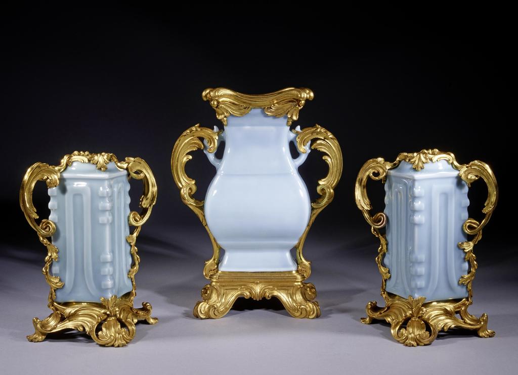 Ensemble de trois vases montés en porcelaine de Chine à couverte « clair de lune », d’époque Yongzheng (1723-1735). 28 x 21,6 x 12,5 cm (vase central), 20 x 18 x 18 cm (pour les vases latéraux). 