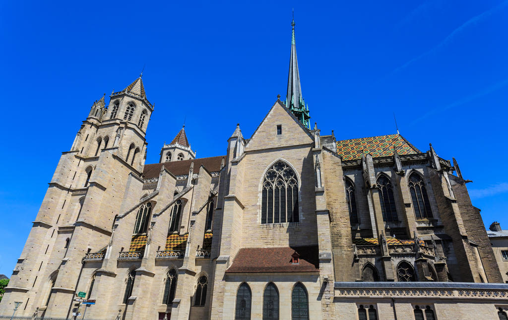 L’actuelle cathédrale Saint-Bénigne de Dijon est une ancienne abbatiale gothique, construite aux XIIIe et XIVe siècles. Les tuiles vernissées et la flèche actuelle datent du XIXe siècle. L’abbatiale du XIe siècle, que flanquait la rotonde, était plus petite. 