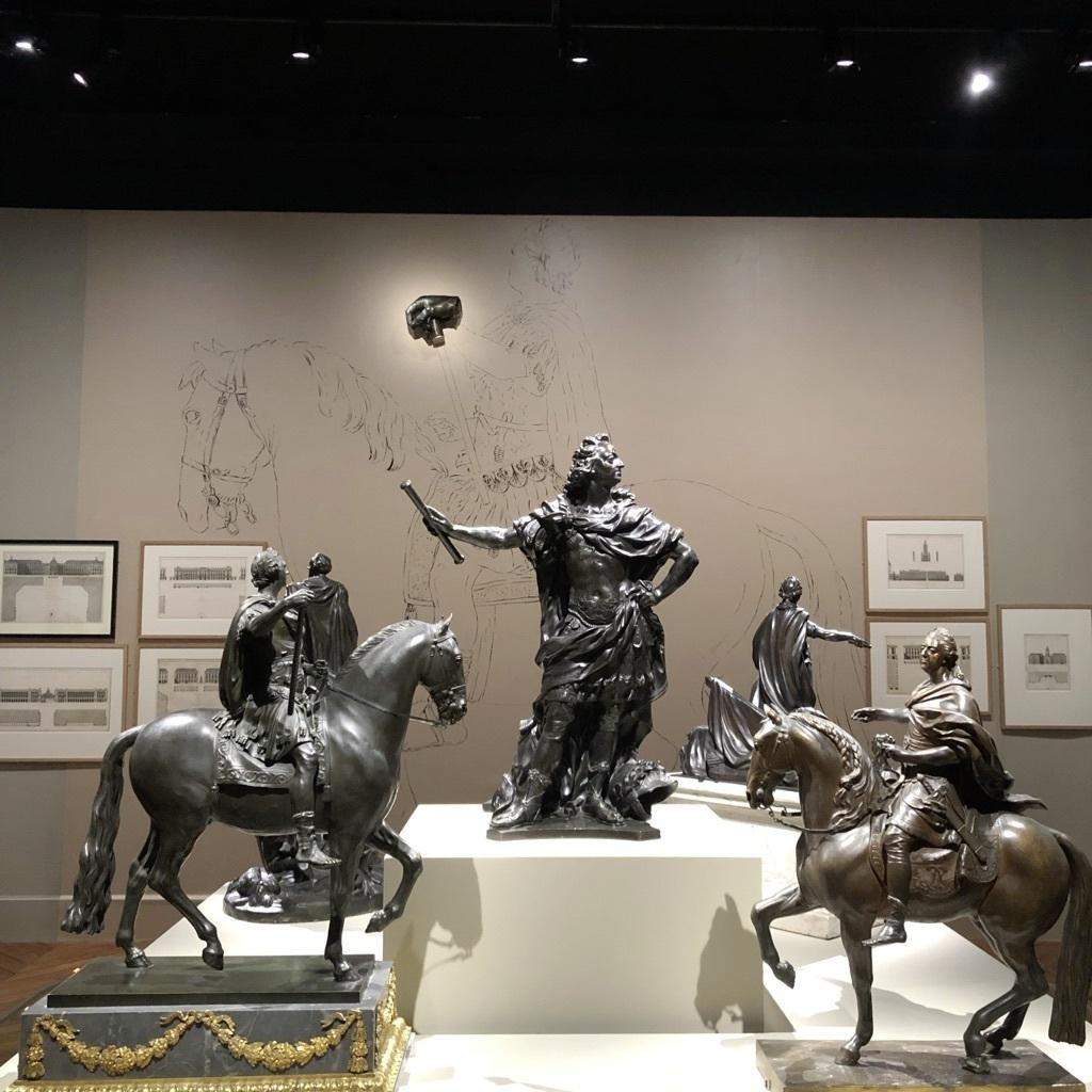 Réductions de différents monuments au « Bien-Aimé » dans l'exposition « Louis XV. Passions d’un roi », organisée à Versailles en 2022. À l'arrière-plan, un fragment du monument de la place Louis XV.