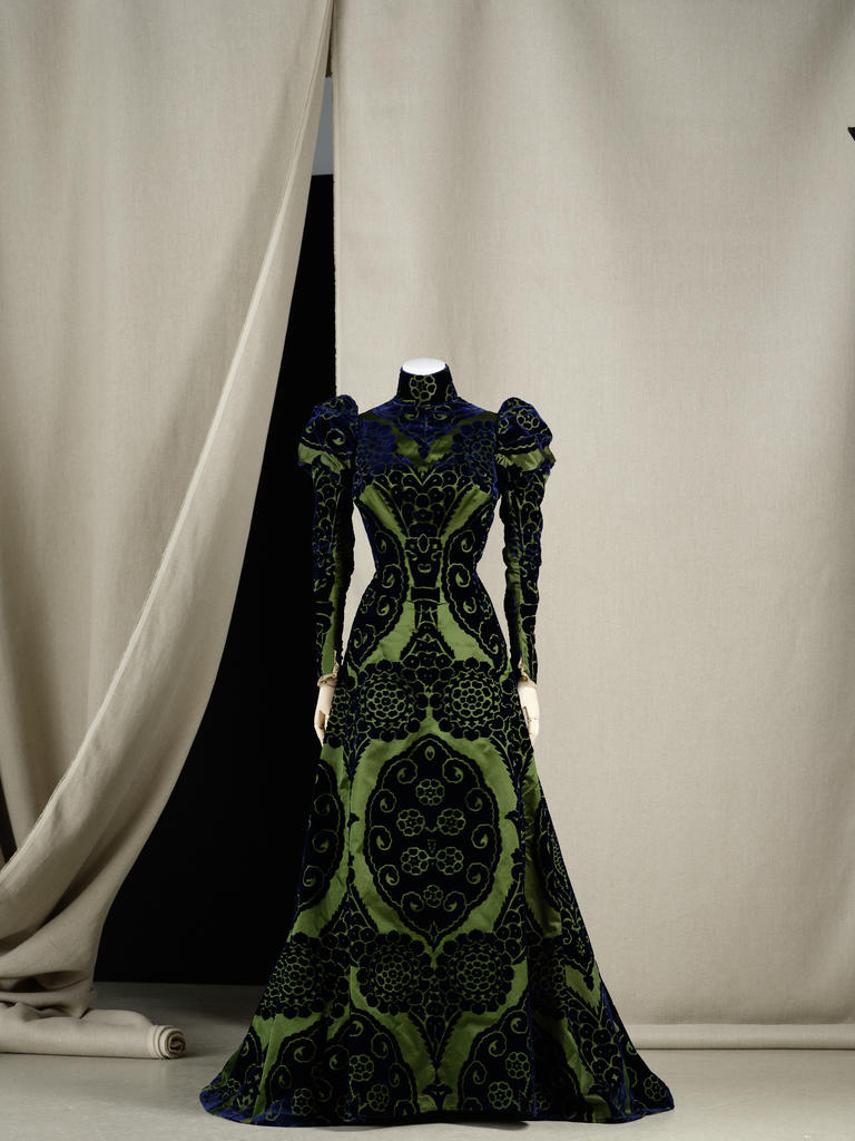 Robe d’intérieur ou tea-gown,  Worth, vers 1897. Soie façonnée à fond en satin vert et motifs en velours coupé bleu ; dentelle de coton mécanique ; doublure en taffetas de soie changeant vert et bleu. Paris, Palais Galliera. 