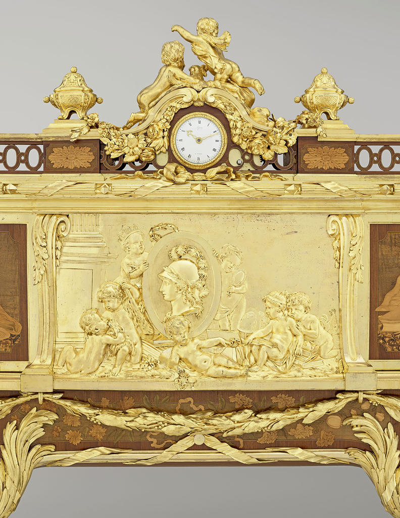 Détail du « bureau du Roi » par Oeben et Riesener montrant le bas-relief de bronze après modification en 1794. Versailles, musée national des châteaux de Versailles et de Trianon.