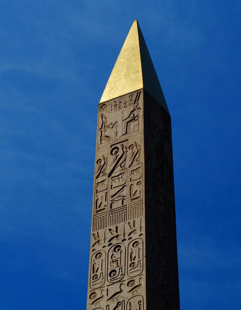 Au sommet de l’obélisque, côté Seine, Ramsès II est représenté en train de faire une offrande au dieu Amon. Il porte une couronne différente de celle qui apparaît sur les trois autres faces. Jean-Guillaume Olette-Pelletier a découvert que l’ensemble de la scène formait une phrase destinée à légitimer son pouvoir et son lien avec le dieu Amon.