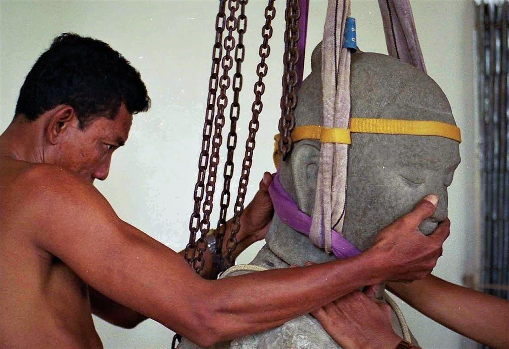 Installation de la tête de la statue du roi Jayavarman VII du Preah Khan Kompong Svay sur son buste découvert en l’an 2000. On notera l’aspect moucheté caractéristique du grès.