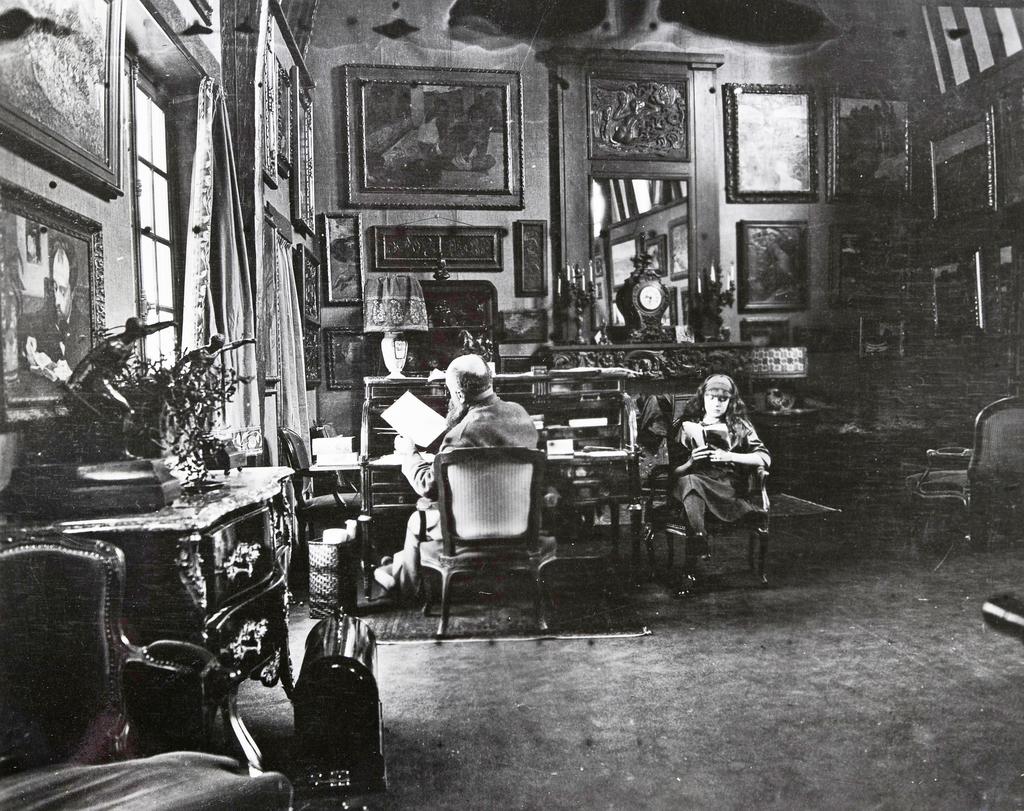 Eugène Druet (1867-1916), Gustave Fayet dans la grange d’Igny avec sa fille Yseult, vers 1912. Photographie. Cet espace était dévolu à la présentation d’une partie de ses collections.