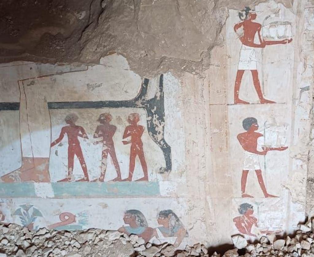 Les décors peints de la tombe d’Amon-em-Ipet, découverte à Dra Abou el-Naga en mai 2025, représentent des porteurs de mobilier funéraire et une scène de banquet. 