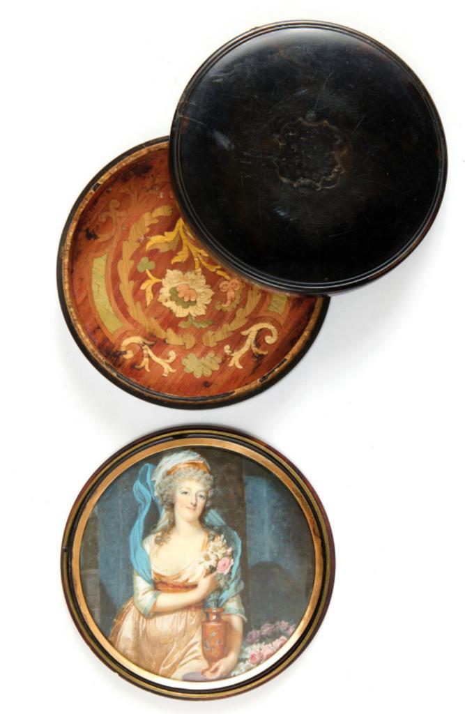 Tabatière à secret de Louis XVI à Varennes à double-fond en écaille dissimulant une miniature de la reine, l’intérieur marqueté de paille teintée décoré de feuillages et de fleurs stylisées. Double-fond orné d’une miniature polychrome de la reine Marie-Antoinette, signée en bas au milieu par François Dumont (1751-1831). Fin du XVIIIᵉ siècle. Diamètre : 8,8 cm. Vente Paris, Auction Art Rémy Le Fur & Associés, le 25 juin 2025. Estimé : 10 000/15 000 €. Adjugé : 53 844 € (frais inclus).
