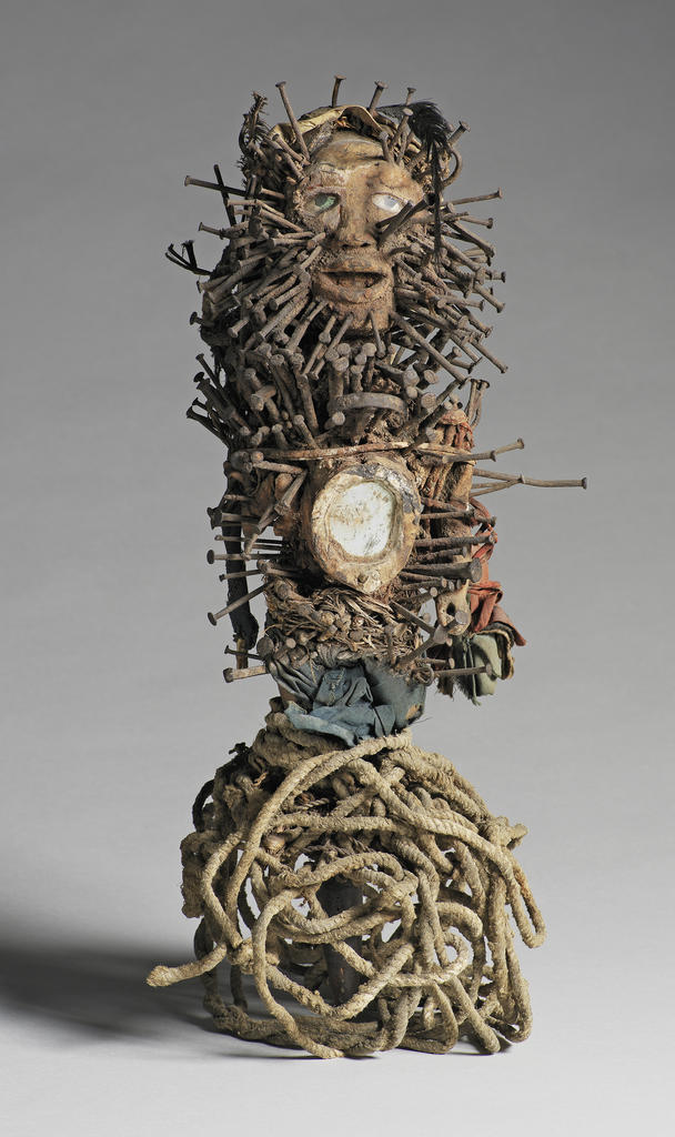 Statuette magique bossue entièrement couverte de clous. Bois, miroir, fer, cordes, plumes, fibres végétales d’origine européenne, Congo, XIXe siècle. 
