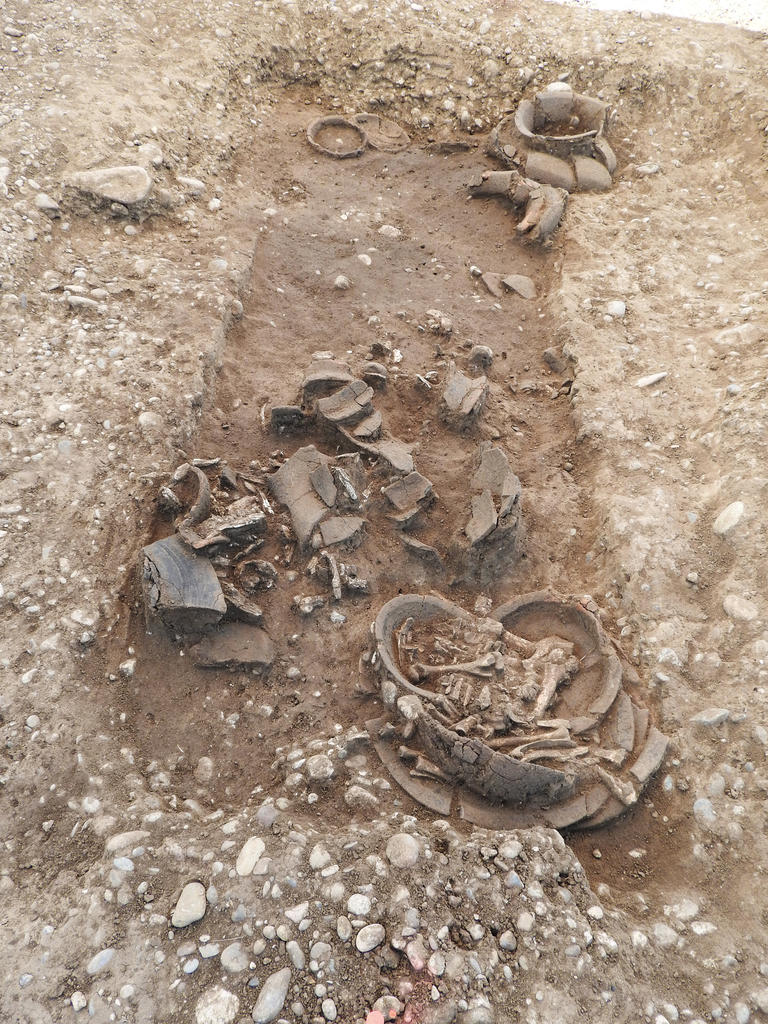 Crémation du bronze final de la nécropole d’Ensisheim (Haut Rhin), vers 1200 avant notre ère. Dans une grande fosse rectangulaire sont déposés l’urne, plusieurs vases et des offrandes alimentaires dans un plat. 