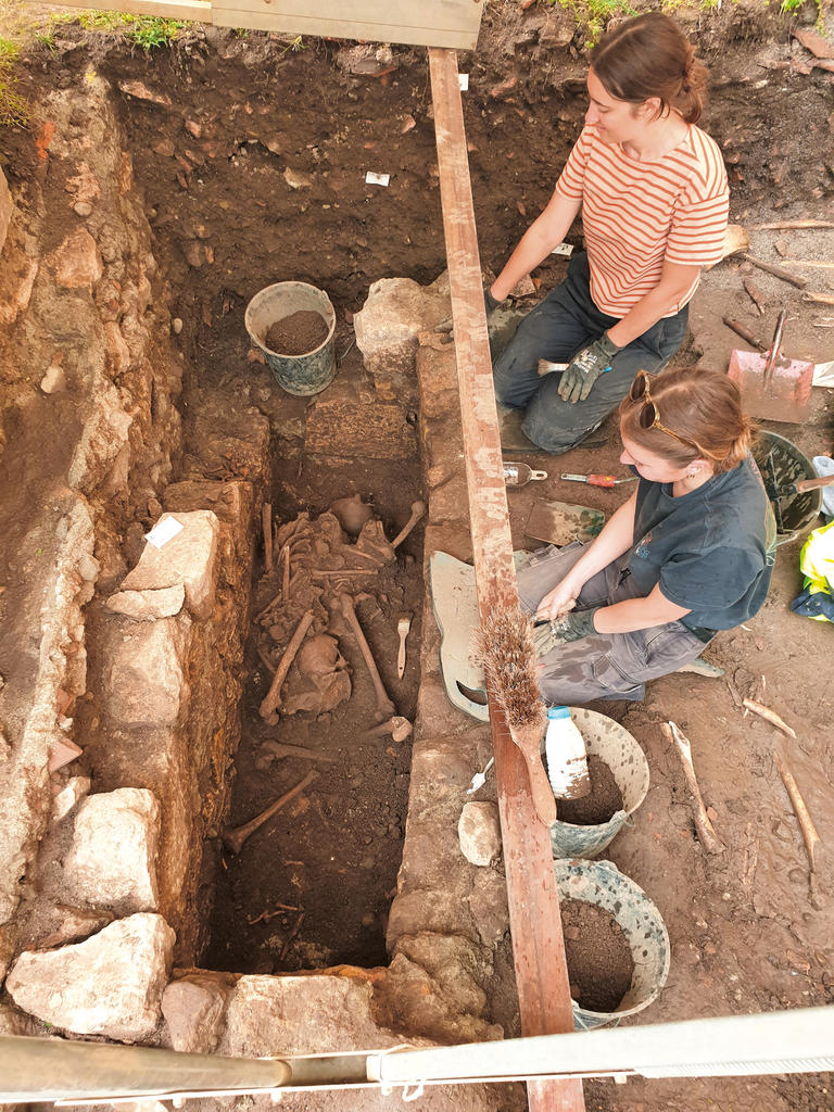 Fouille d’une tombe médiévale accueillant plusieurs défunts. C’est dans et autour de l’église Saint-Jean-Baptiste que les fouilles d’Hadès ont mis au jour une cinquantaine de sépultures. Si une douzaine de défunts reposait dans des coffres maçonnés, les très nombreux autres ont été inhumés en pleine terre, créant parfois un imbroglio de corps emmêlés. De rares chapelets, des fibules attachant le linceul et une dizaine de monnaies figurent parmi les vestiges identifiés et aideront à préciser les phases d’occupation et d’organisation des lieux.