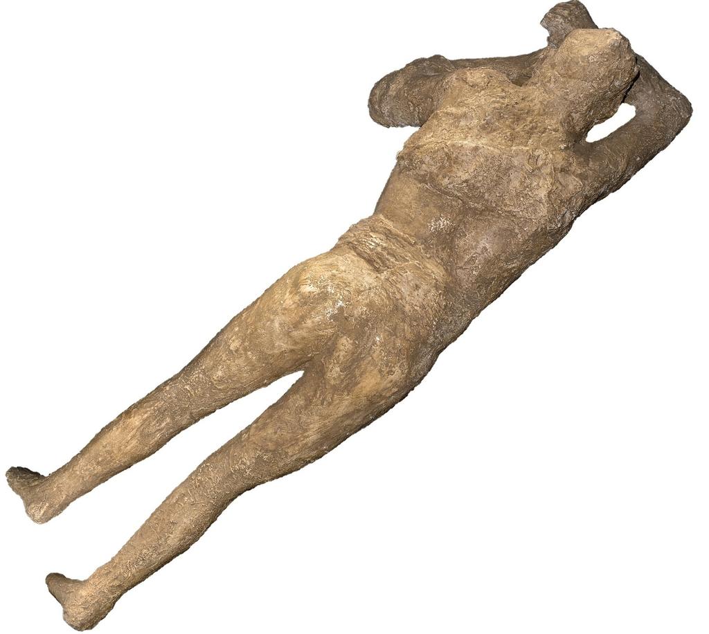 Moule en plâtre d’une victime de Pompéi (femme). À la différence de la coulée brûlante qui touche Herculanum et carbonise tout sur son passage, celle qui atteint Pompéi au matin, d’une température moins élevée, préserve les corps asphyxiés ; d’épaisses couches de cendres se consolident autour d’eux. Dans les années 1860, l’archéologue Giuseppe Fiorelli coule du plâtre à l’intérieur des cavités laissées par les corps décomposés dans la cendre fossilisée. C’est ainsi que sont créés les saisissant moulages des victimes de Pompéi.