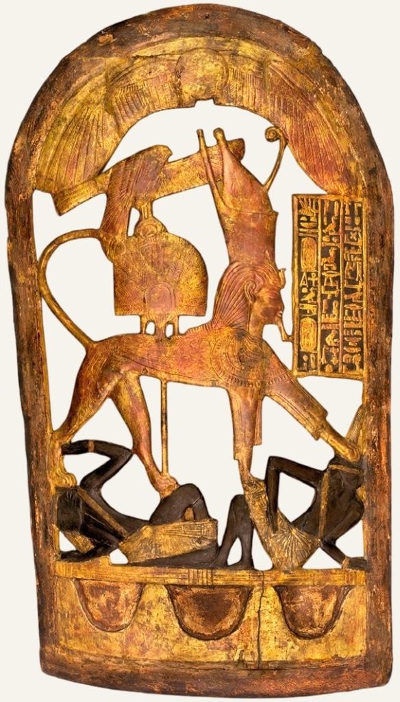 Bouclier cérémoniel en bois doré représentant le roi sous les traits d’un sphinx piétinant les ennemis nubiens. Bois, stuc, feuille d’or et incrustations d’ébène, H. : 89,5 cm. Règne de Toutânkhamon (1336-1326 avant notre ère), Louxor, vallée des Rois, KV62. Le Caire, Grand musée égyptien, GEM 341.