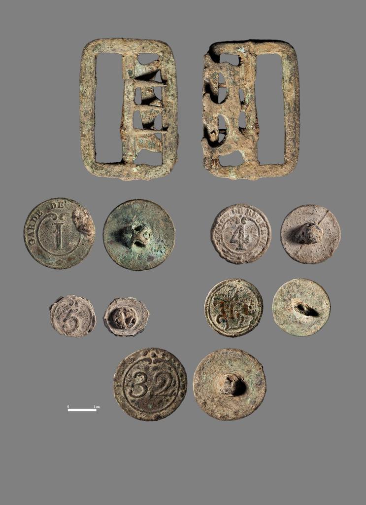 Boucle et boutons militaires découverts en 2024 dans la « caverne des dragons » sur l’île‐prison de Cabrera (Baléares). 