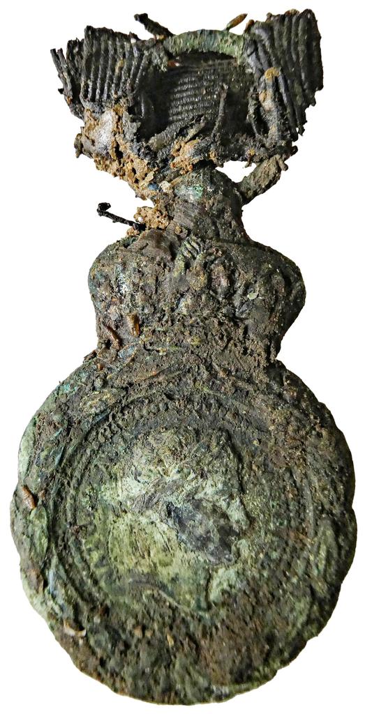 La médaille de Sainte‐Hélène découverte sur le squelette exhumé à Cons-la-Granville en 2021. Elle a rendu possible l’identification du soldat de la Garde impériale Jean-Jacques Zentz, décédé en 1876. La médaille de Sainte‐Hélène fut créée en 1857 par Napoléon III pour les vétérans des campagnes de 1792 à 1815. 
