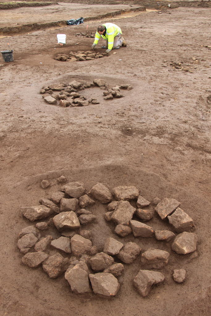 Vue de plusieurs foyers à pierres chauffées en cours de fouille.